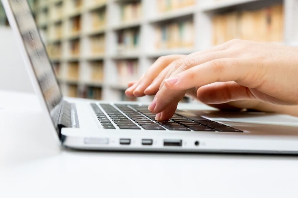 hands typing on computer in library